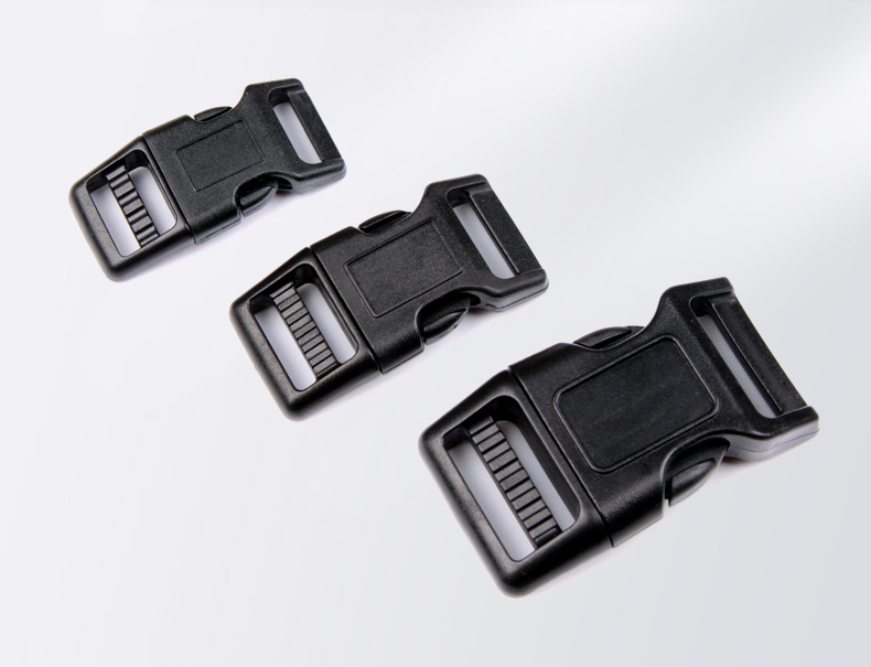 Close view of a black POM side-release buckle opened by hand